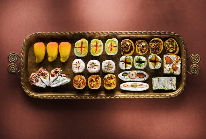 A brass tray of Indian sweets finished with edible gold and silver leaf